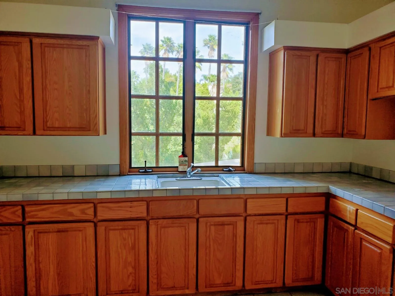 14316 Twisted Branch Road Poway, CA 92064 - Photo 30 of 36 a kitchen with granite countertop wooden cabinets a sink and a window
