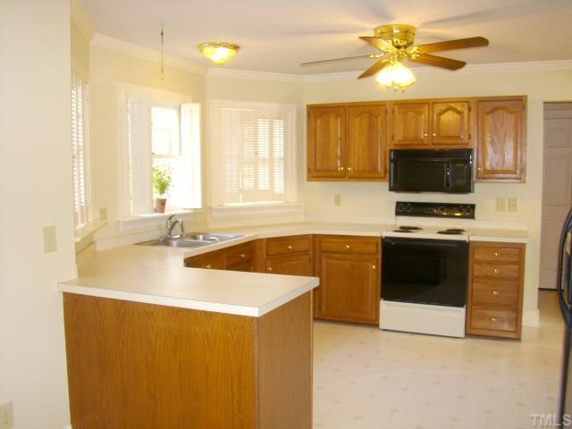 3409 Greenville Loop Road Wake Forest, NC 27587 - Photo 3 of 12 a kitchen with stainless steel appliances a stove a sink and a microwave