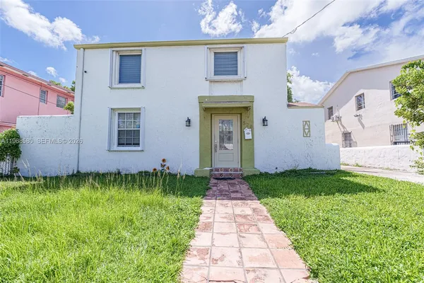 a front view of a house with a garden