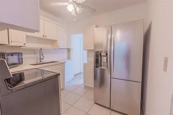 a kitchen with stainless steel appliances granite countertop a refrigerator a sink and a stove