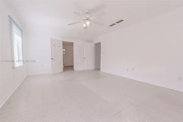 a view of an empty room with a ceiling fan