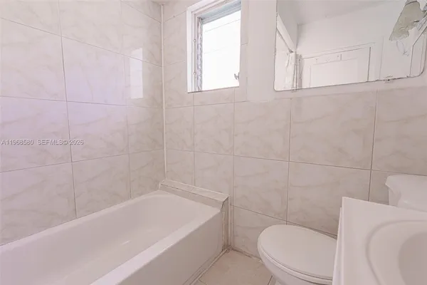 a bath room with a toilet a bath tub and a shower