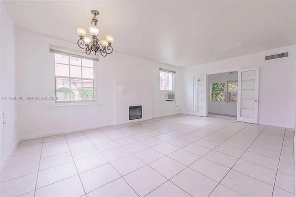 an empty room with windows and chandelier