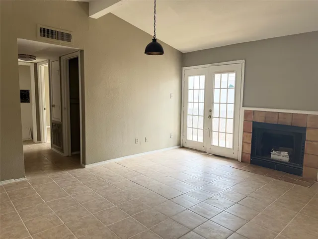 a view of an empty room with a fireplace and a window
