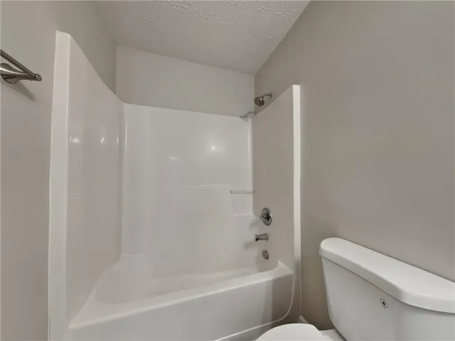 a bath room with a toilet and a bath tub