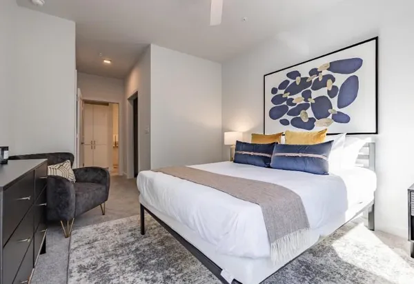 a bedroom with a bed and painting on wall