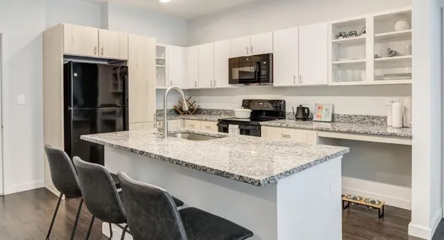 a kitchen with granite countertop a sink and cabinets