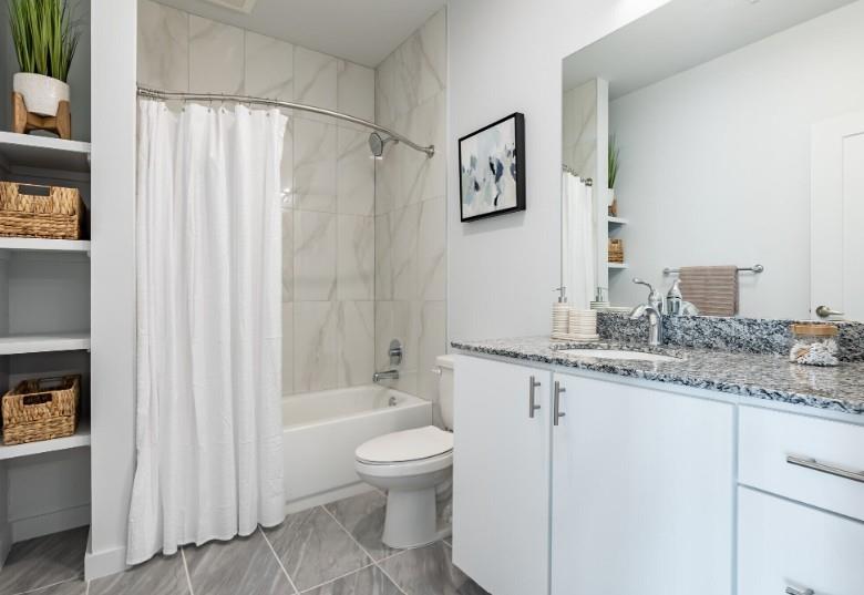 750 Avondale Creek Dr., Unit 206 Decatur, GA 30032 - Photo 22 of 35 a bathroom with a granite countertop sink a toilet and a bathtub