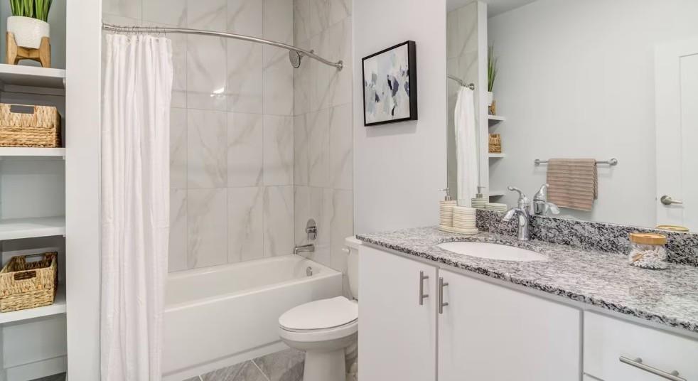 750 Avondale Creek Dr., Unit 206 Decatur, GA 30032 - Photo 24 of 35 a bathroom with a granite countertop sink mirror toilet and bathtub