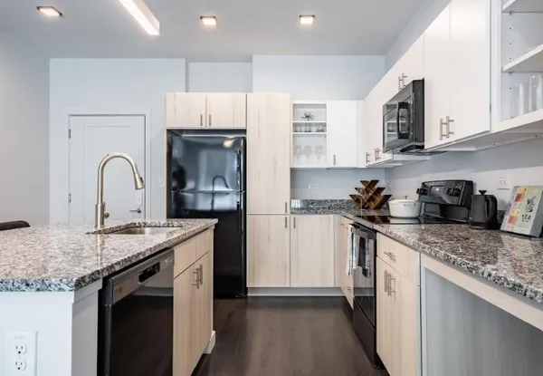 a kitchen with stainless steel appliances granite countertop a sink stove and cabinets
