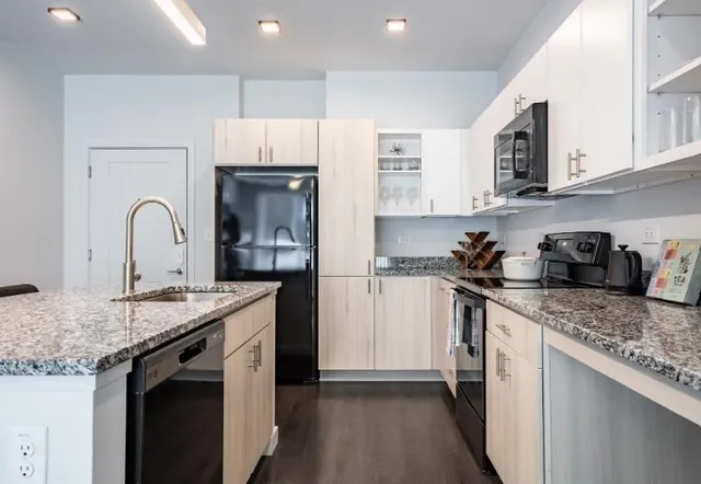 a kitchen with stainless steel appliances granite countertop a sink stove and cabinets