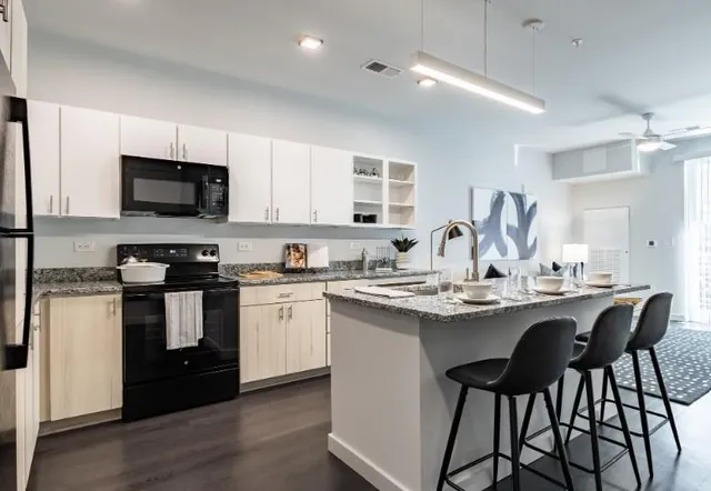 a kitchen with stainless steel appliances kitchen island granite countertop a sink and cabinets