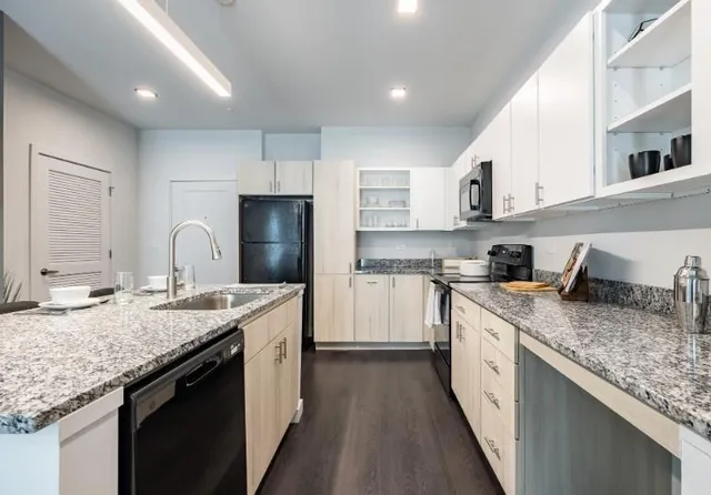 a kitchen with stainless steel appliances granite countertop a sink stove and refrigerator