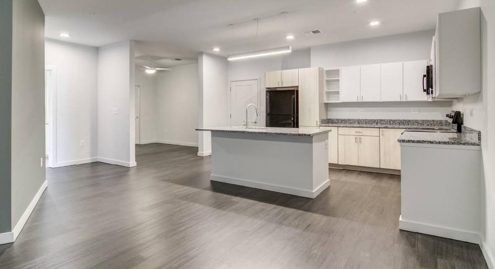 750 Avondale Creek Dr., Unit 206 Decatur, GA 30032 - Photo 9 of 35 a kitchen with stainless steel appliances granite countertop a stove top oven a sink and white cabinets with wooden floor