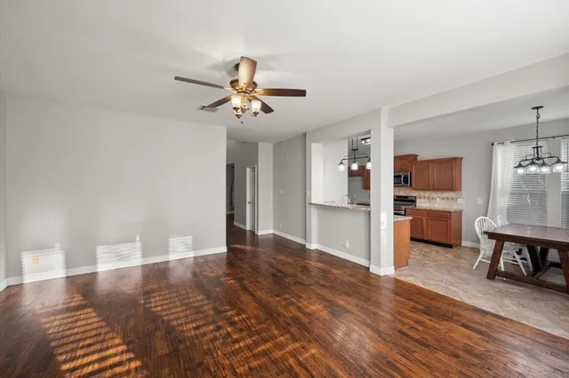 a dining hall with stainless steel appliances granite countertop a sink dishwasher a dining table and chairs with wooden floor