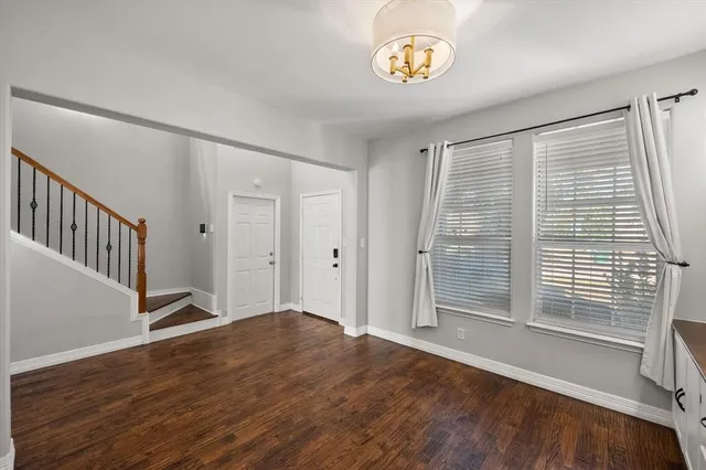 a view of an empty room with wooden floor a fireplace and a ceiling fan