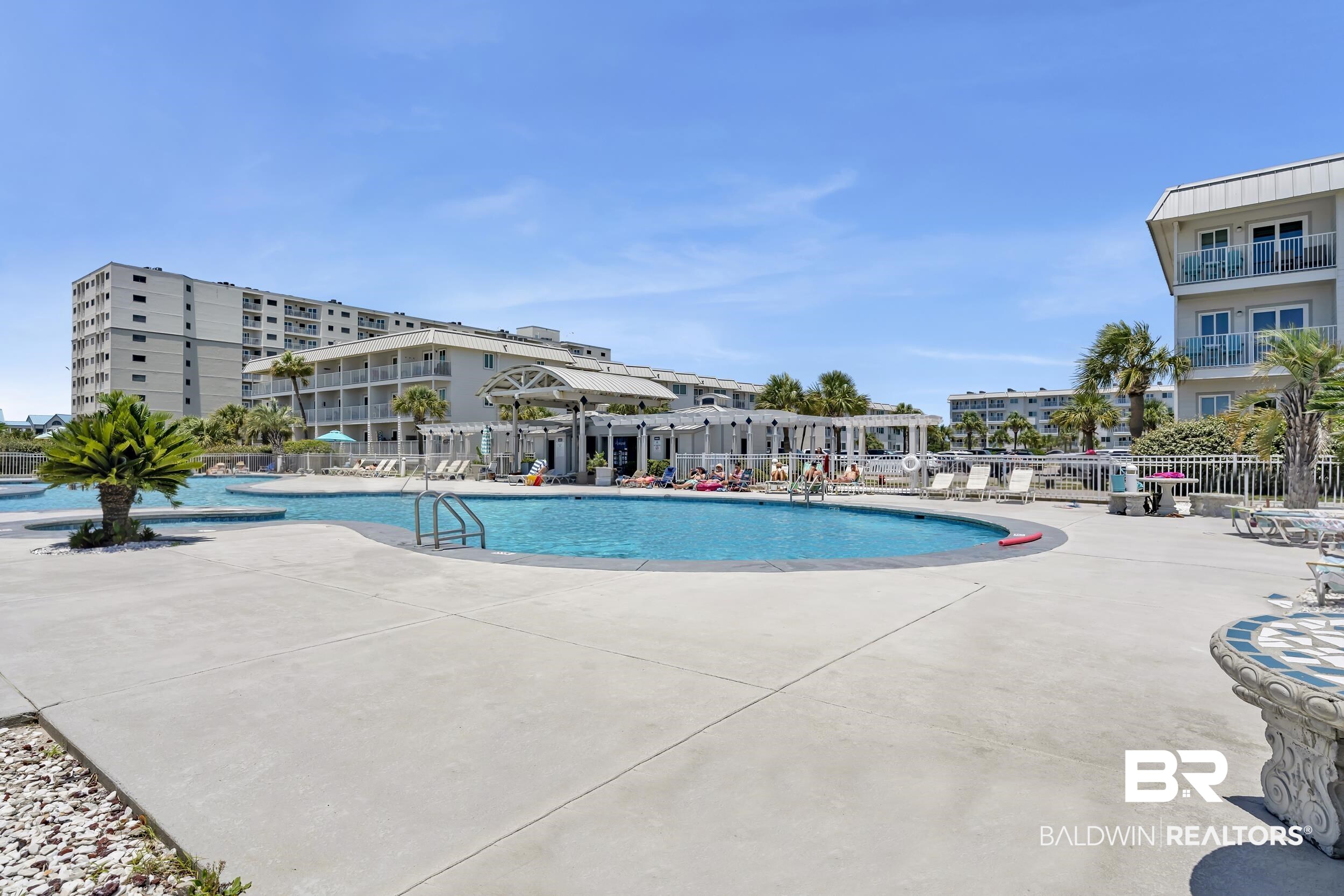 400 Plantation Road, Unit 2118 Gulf Shores, AL 36542 - Photo 27 of 59 Expansive outdoor pool deck featuring a large swimming pool, surrounding concrete patio, and a shaded pergola area