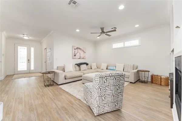 a dining room with wooden floor a chandelier a wooden table and chairs