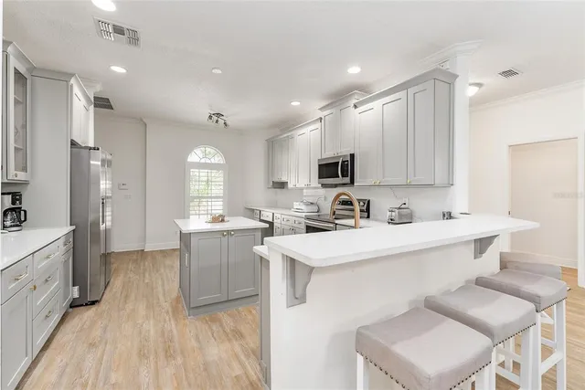 a large white kitchen with sink and furniture