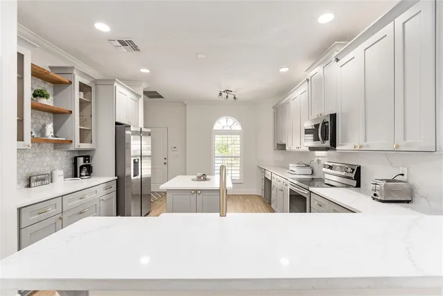 a kitchen with a sink a stove a microwave and wooden cabinets