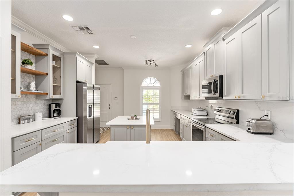 4987 Southwest 63rd Loop Ocala, FL 34474 - Photo 19 of 56 a large white kitchen with stainless steel appliances