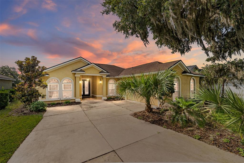4987 Southwest 63rd Loop Ocala, FL 34474 - Photo 2 of 56 a front view of a house with a yard and garage