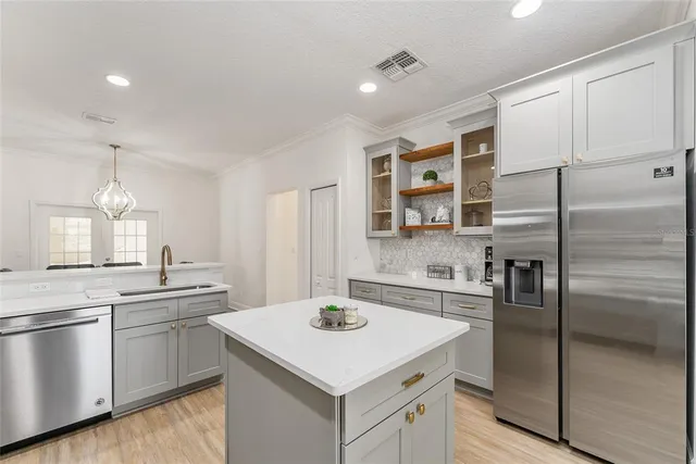 a kitchen with a sink cabinets and wooden floor