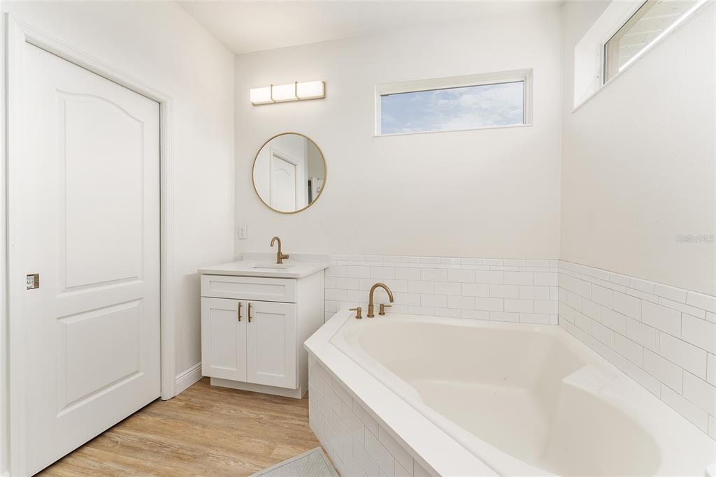 4987 Southwest 63rd Loop Ocala, FL 34474 - Photo 36 of 56 a spacious bathroom with a tub sink and mirror