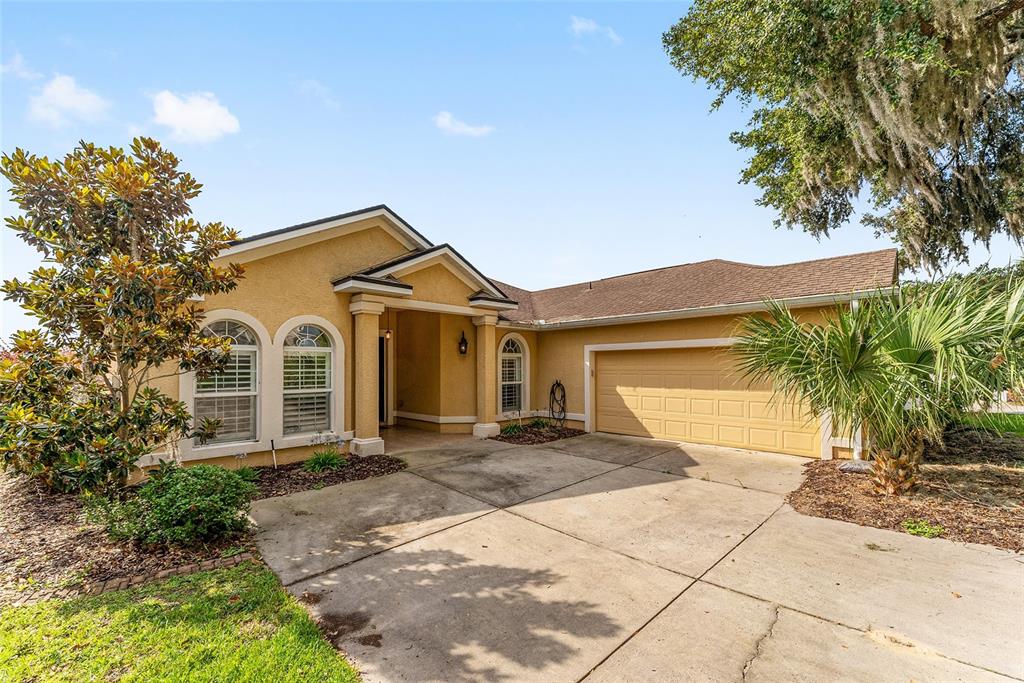 4987 Southwest 63rd Loop Ocala, FL 34474 - Photo 55 of 56 a front view of a house with a yard and garage