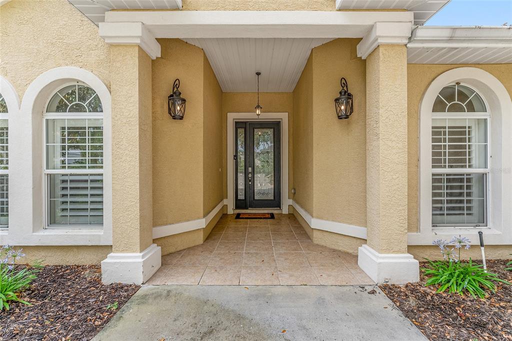 4987 Southwest 63rd Loop Ocala, FL 34474 - Photo 6 of 56 a front view of a house with a glass door