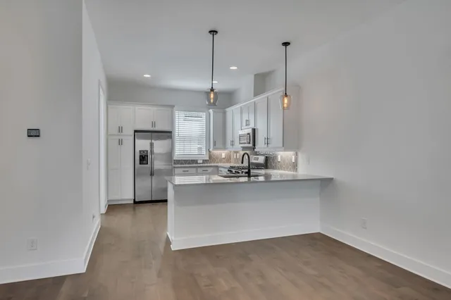 a kitchen with stainless steel appliances a refrigerator sink and microwave