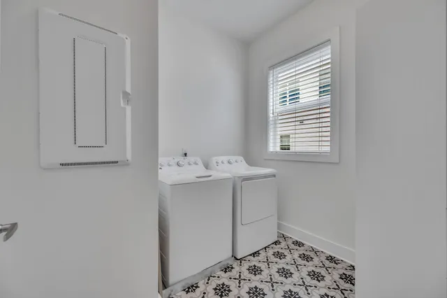 a utility room with a sink a cabinetry and a window