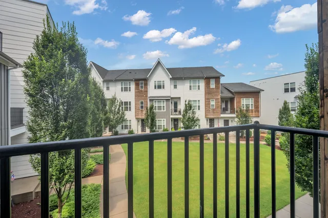 a view of a house with large windows and wooden fence