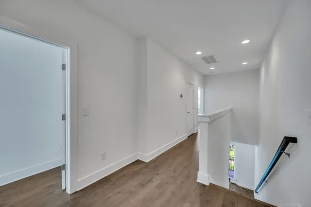 a view of an empty room with wooden floor