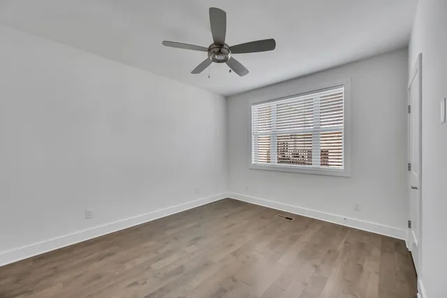 wooden floor in an empty room with a window