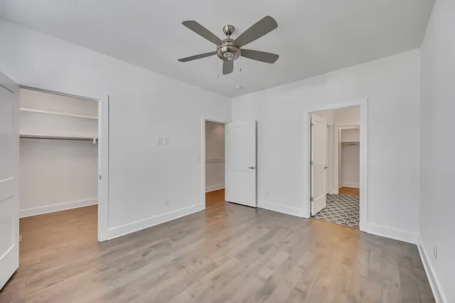 an empty room with closet and a ceiling fan
