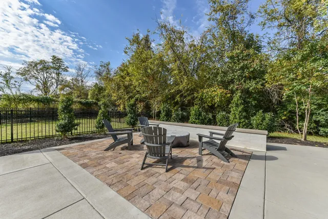 a bench sitting in middle of a park with large trees