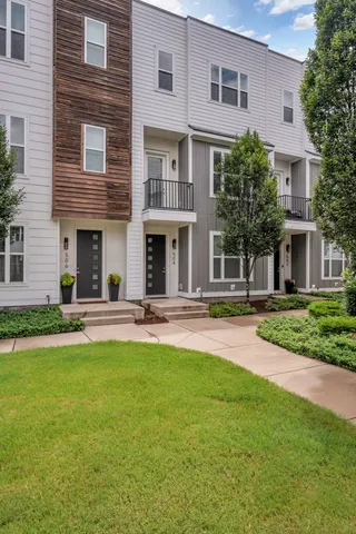 a front view of a house with yard and green space