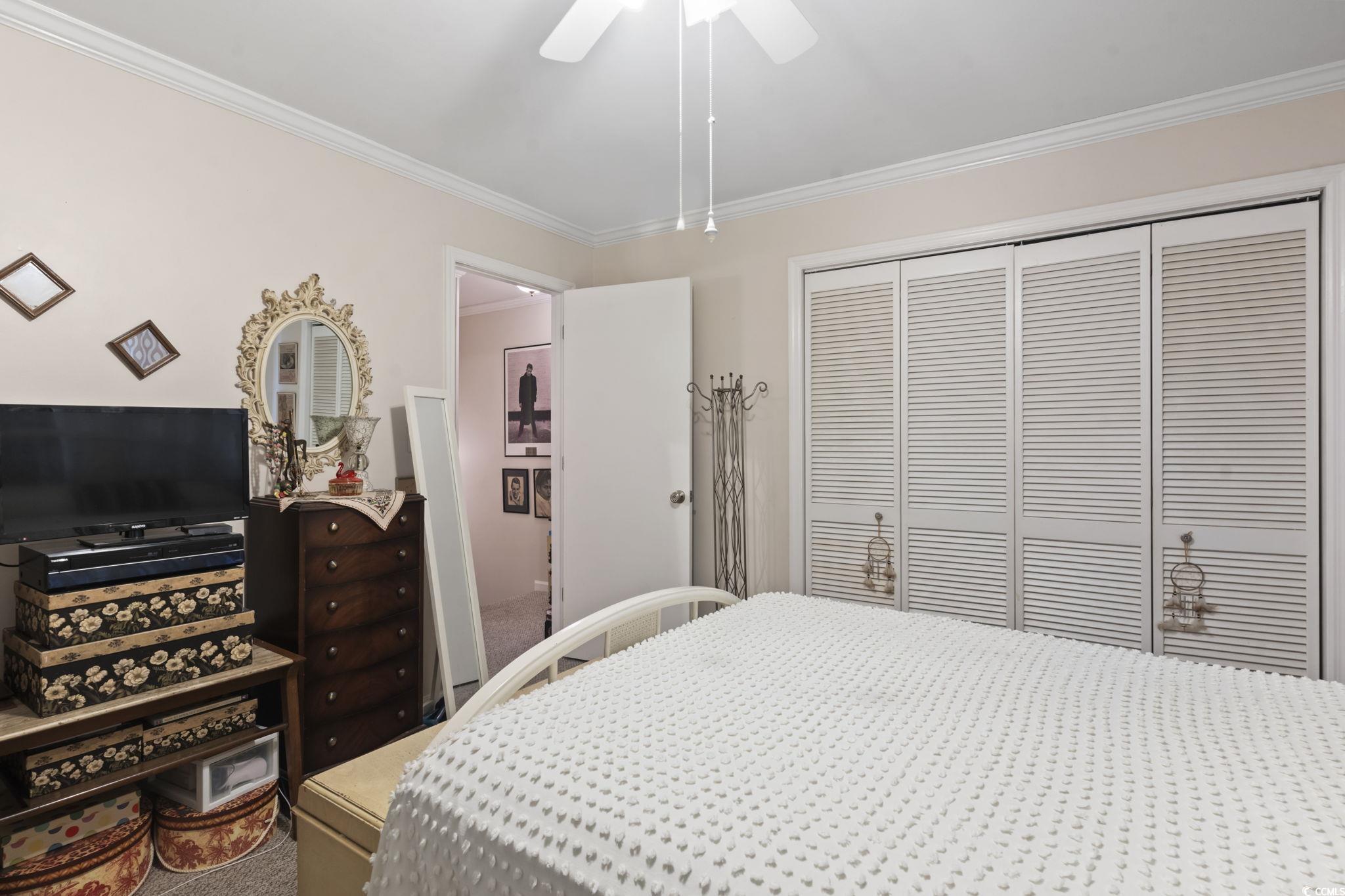 55 Beaver Pond Loop, Unit 15 Pawleys Island, SC 29585 - Photo 16 of 24 Carpeted bedroom featuring crown molding, a closet, and a ceiling fan