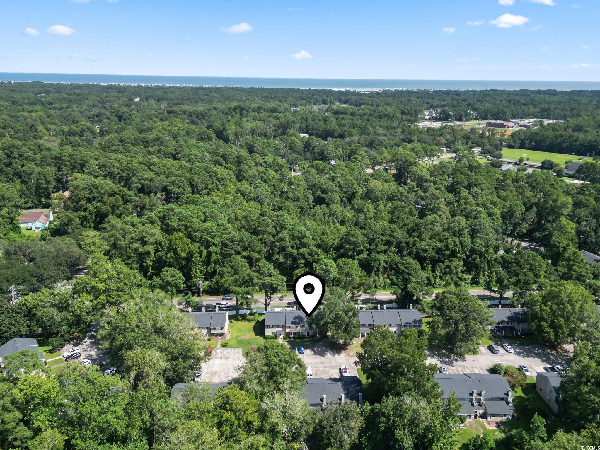 55 Beaver Pond Loop, Unit 15 Pawleys Island, SC 29585 - Photo 2 of 24 Aerial view of property's location with a heavily wooded area