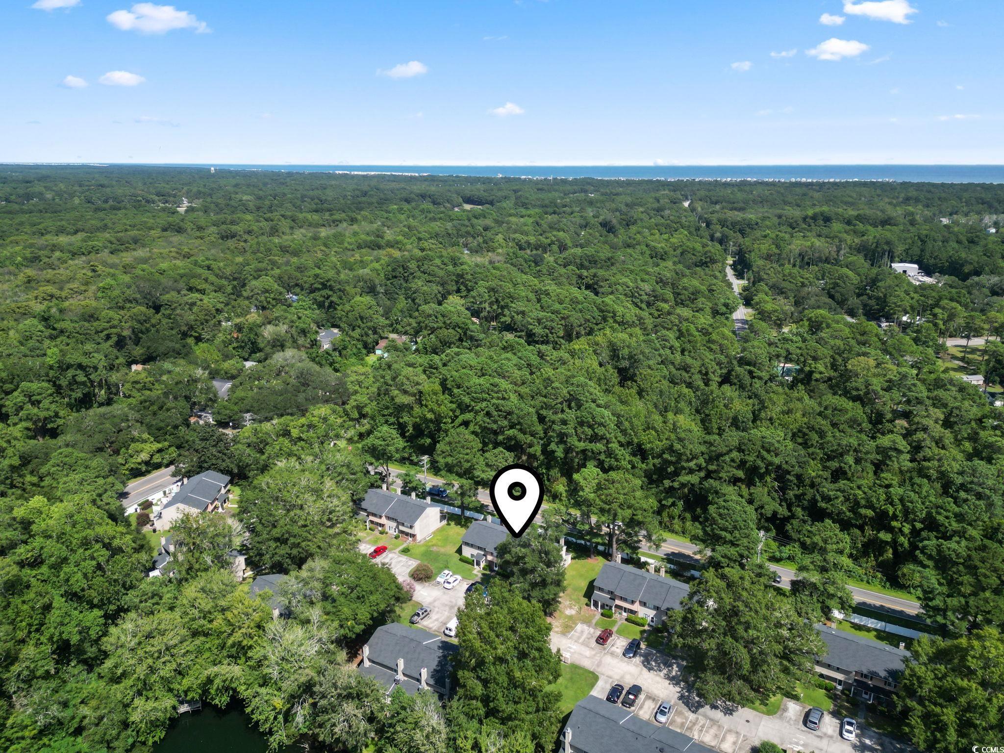 55 Beaver Pond Loop, Unit 15 Pawleys Island, SC 29585 - Photo 3 of 24 Aerial view of property's location with a heavily wooded area and a nearby body of water