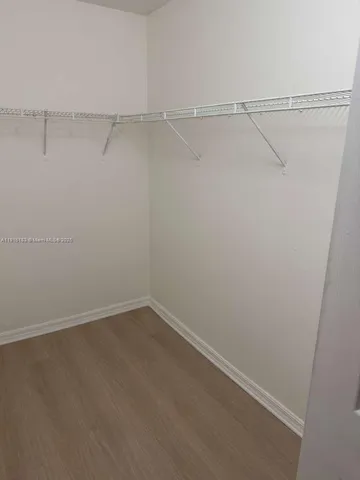 an empty room with wooden floor and window