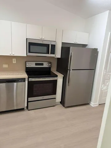 a kitchen with cabinets and stainless steel appliances