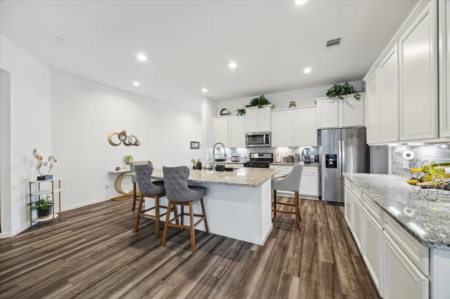 a kitchen with granite countertop lots of counter top space dining table and chairs