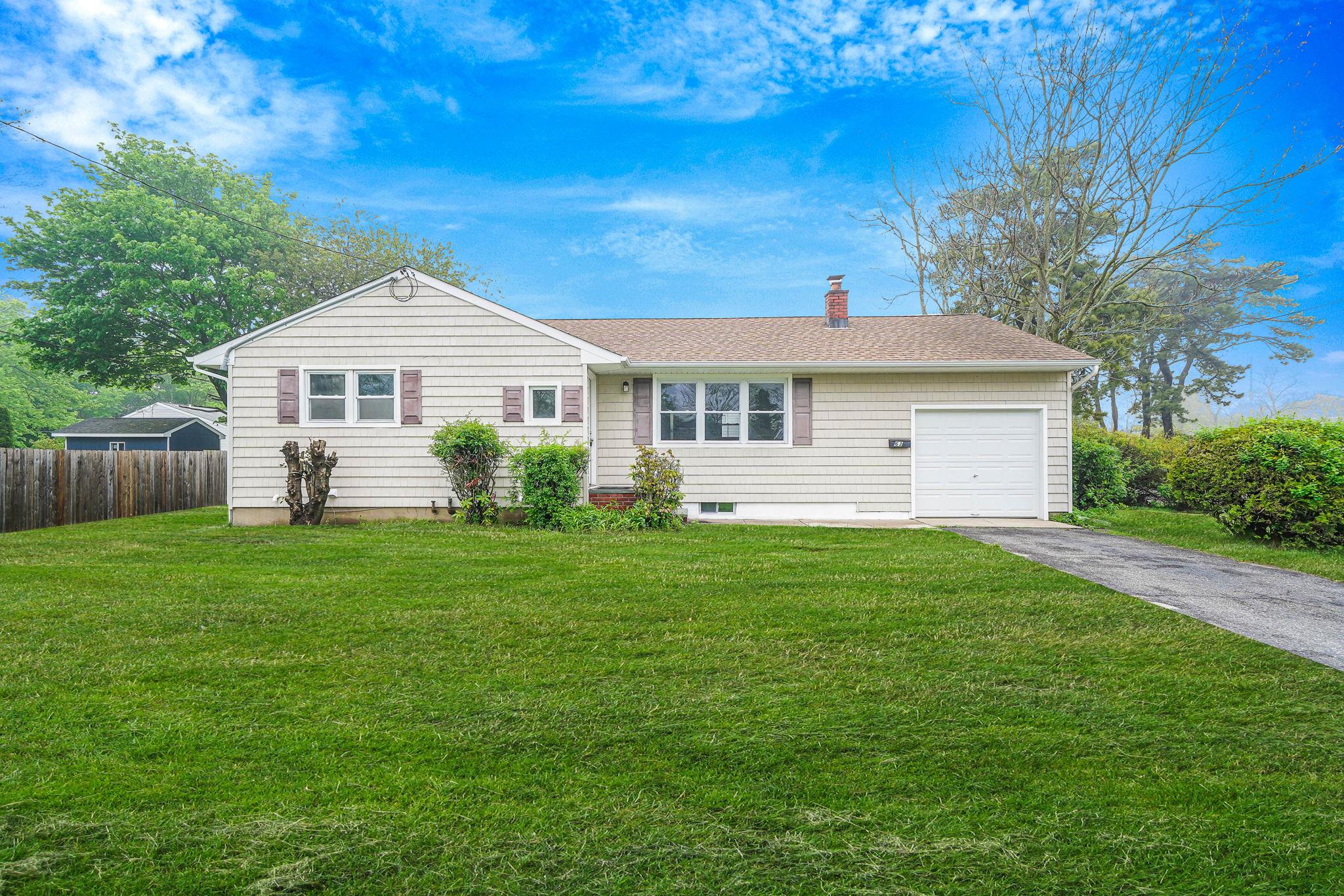 63 Beaver Dam Road Bellport, NY 11713 - Photo 1 of 1 a front view of a house with a garden