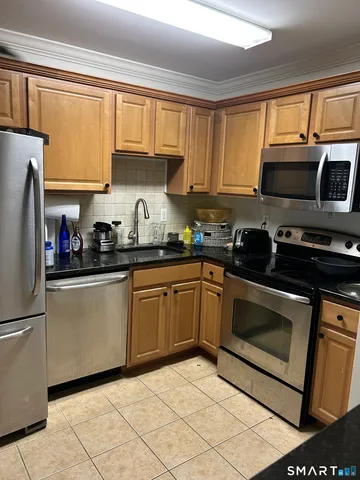 a kitchen with granite countertop a sink stainless steel appliances and cabinets