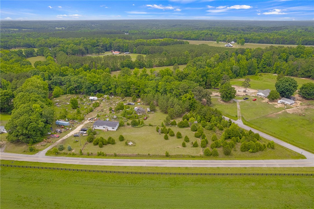 1549 Bethany Church Road Belton, SC 29627 - Photo 5 of 36 An aerial perspective reveals a vast expanse of verdant land, dotted with mature trees and a tranquil rural setting.