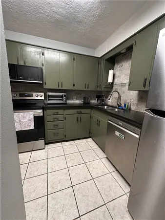 a kitchen with granite countertop a sink and a stove top oven