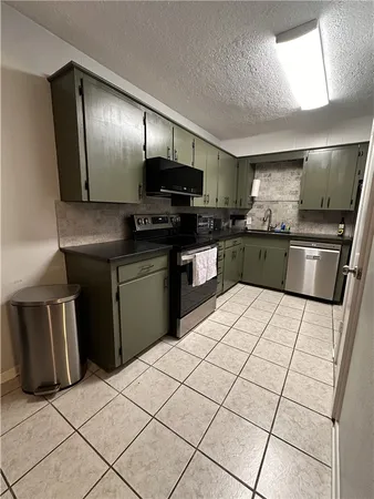 a kitchen with stainless steel appliances granite countertop a refrigerator sink and stove