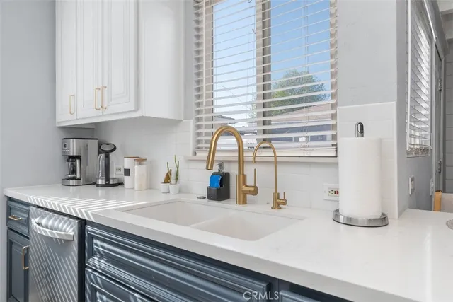 a kitchen with kitchen island a sink a stove and white cabinets